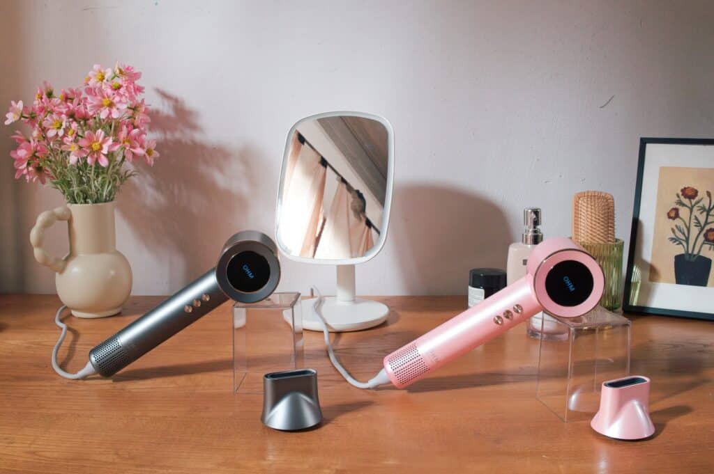 High-quality OHM Ultra+ Hair Dryers in pink and grey on a wooden surface.